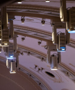 Una vista del soffitto di un teatro mette in mostra numerosi PC LED 700W Followspot, installati per evidenziare i dettagli architettonici elaborati. Queste luci sono angolate verso il basso, pronte a illuminare uno spazio per spettacoli.
